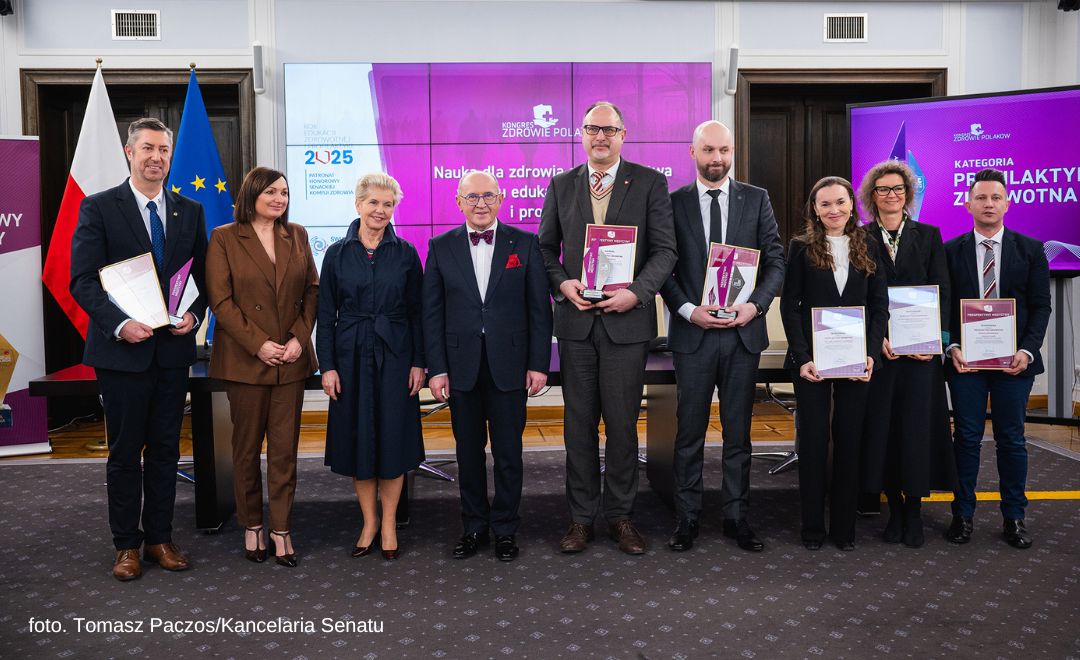 grupa ludzi z dyplomami pozujących do zdjęcia